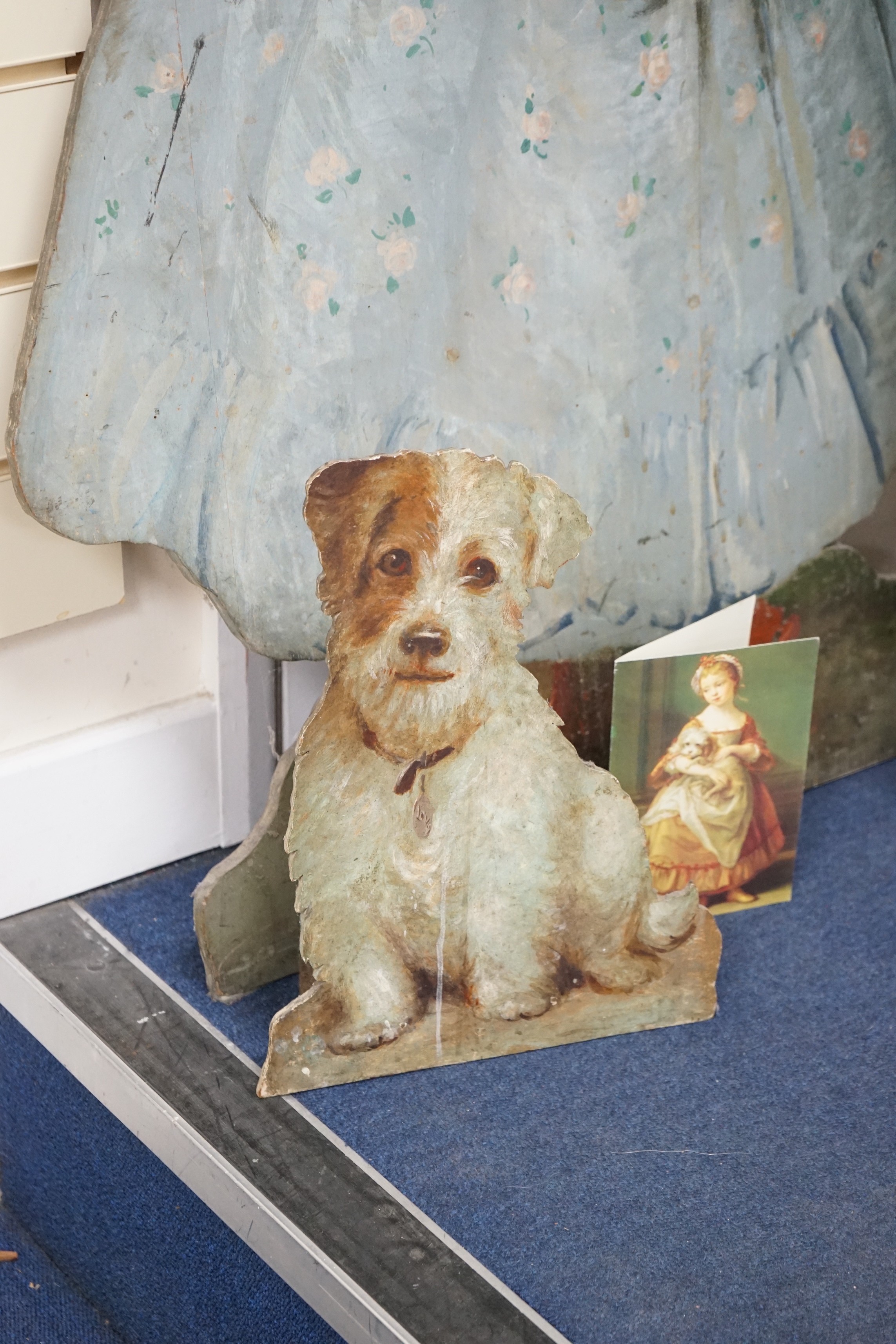 Two painted wood dummy boards, early 20th century, standing figure of a young girl holding a dog, in imitation of Pompeo Batoni (1708-1787), portrait of Countess Stanhope, 112cm tall, together with a smaller wood standin